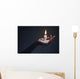 Holding a candle on a dark background. Wall Mural