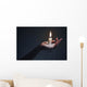 Holding a candle on a dark background. Wall Mural
