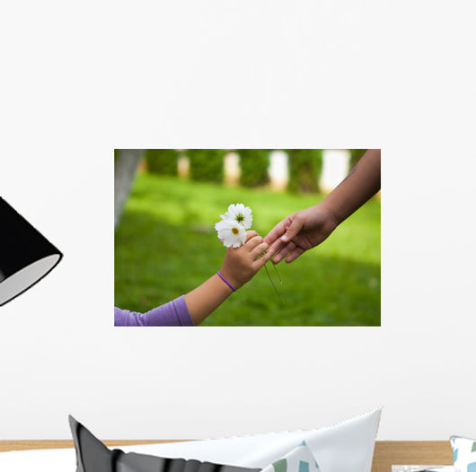 Child's hand giving flowers to her friend Wall Mural