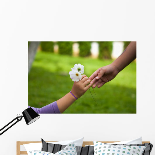Child's hand giving flowers to her friend Wall Mural