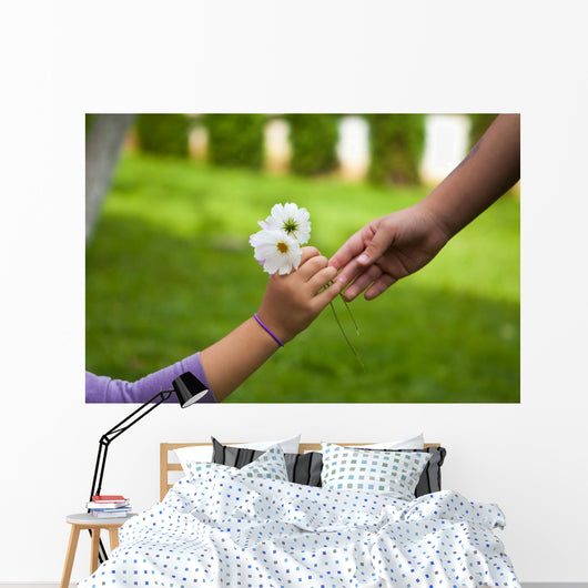 Child's hand giving flowers to her friend Wall Mural