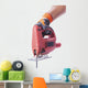 hand in a glove holds a working electric jig saw Wall Decal