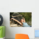 Happy woman relaxing on a hammock on holidays and raising arms Wall Mural