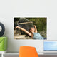 Happy woman relaxing on a hammock on holidays and raising arms Wall Mural
