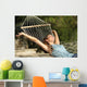Happy woman relaxing on a hammock on holidays and raising arms Wall Mural