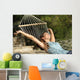 Happy woman relaxing on a hammock on holidays and raising arms Wall Mural