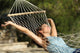 Happy Woman Relaxing On A Hammock On Holidays And Raising Arms Wall Decal