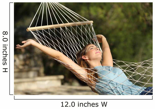 Happy woman relaxing on a hammock on holidays and raising arms Wall Mural