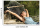 Happy woman relaxing on a hammock on holidays and raising arms Wall Mural