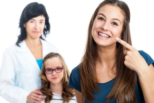 Teen Girl Pointing At Dental Braces With Doctor In Background. Wall Decal