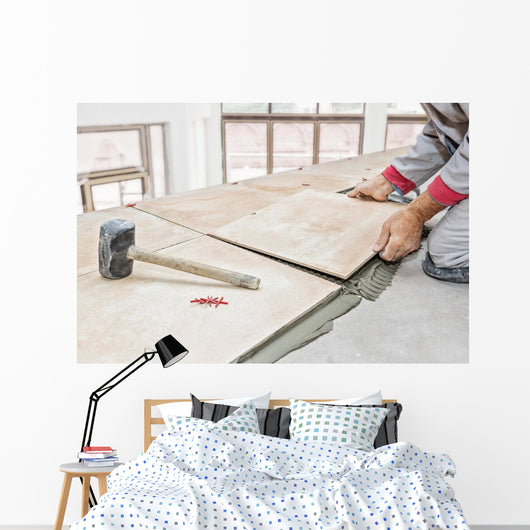 Handyman laying tile, trowel with mortar Wall Mural