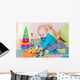 Cute little baby playing with colorful toys indoors Wall Mural