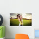 Woman golf player swinging with golf club Wall Mural