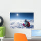 Hiker posing at top of snowy mountain during sunny day Wall Mural
