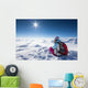 Hiker posing at top of snowy mountain during sunny day Wall Mural