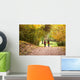Young love couple, holding hands walking in the autumn forest Wall Mural