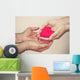hands holding a red heart Wall Mural