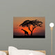 Silhouetted tree and giraffe against a red sunset Wall Mural