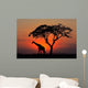 Silhouetted tree and giraffe against a red sunset Wall Mural