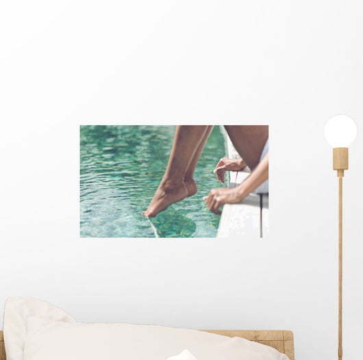 Young Woman Sitting at Poolside with Toes on Water Wall Mural
