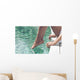 Young Woman Sitting at Poolside with Toes on Water Wall Mural