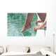 Young Woman Sitting at Poolside with Toes on Water Wall Mural