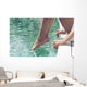 Young Woman Sitting at Poolside with Toes on Water Wall Mural
