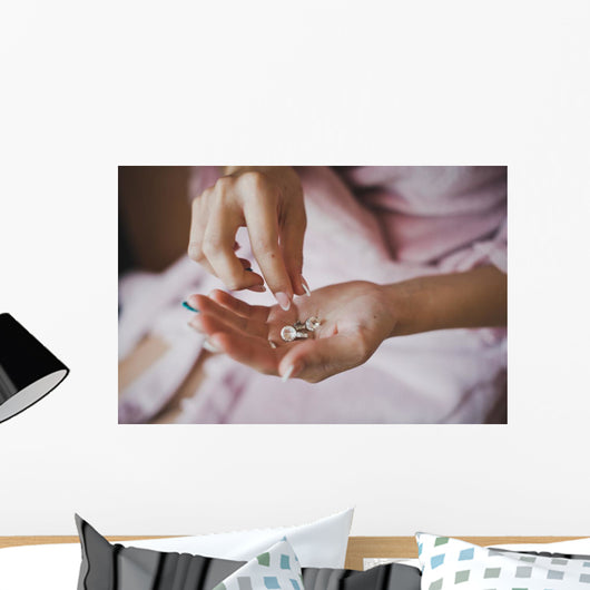 Earrings from pearls in hands 1278. Wall Mural
