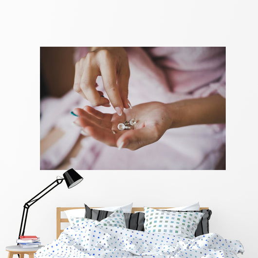 Earrings from pearls in hands 1278. Wall Mural