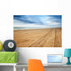 Perspective of tyre tracks on sandy beach Wall Mural