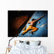Muscular man practicing rock-climbing on a rock wall indoors Wall Mural