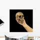Holding human skull in hand. Conceptual image. Wall Mural