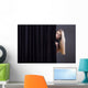 Frightened girl hiding behind a curtain. Wall Mural