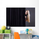 Frightened girl hiding behind a curtain. Wall Mural