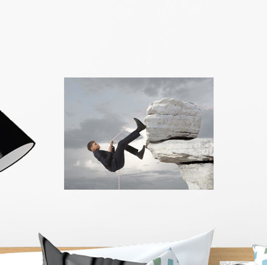 Young businessman scaling a rock Wall Mural