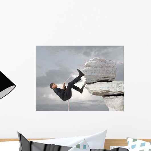 Young businessman scaling a rock Wall Mural