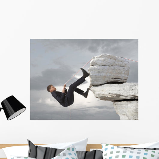Young businessman scaling a rock Wall Mural