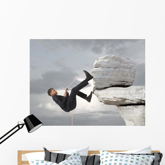 Young businessman scaling a rock Wall Mural