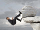 Young businessman scaling a rock Wall Mural