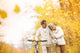 Senior couple with bicycle in autumn park Wall Mural