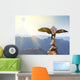 Wedge-tailed Eagle landing on rock cairn on mountain top Wall Mural