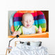 Adorable baby eating in high chair Wall Mural