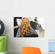 Blonde curly hair. Hairdresser doing hairstyle for young woman i Wall Mural