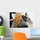 Blonde curly hair. Hairdresser doing hairstyle for young woman i Wall Mural