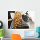 Blonde curly hair. Hairdresser doing hairstyle for young woman i Wall Mural