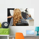Blonde curly hair. Hairdresser doing hairstyle for young woman i Wall Mural