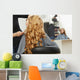 Blonde curly hair. Hairdresser doing hairstyle for young woman i Wall Mural