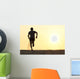 Back view silhouette of a runner man running on the beach Wall Mural