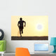Back view silhouette of a runner man running on the beach Wall Mural