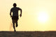 Back view silhouette of a runner man running on the beach Wall Mural